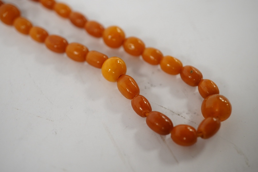 A single strand amber bead necklace, 72cm, gross weight 14 grams, together with a Victorian silver and malachite inset vinaigrette(a.f.) and a white metal and Scottish hardstone set bracelet(a.f.). Condition - poor to fa